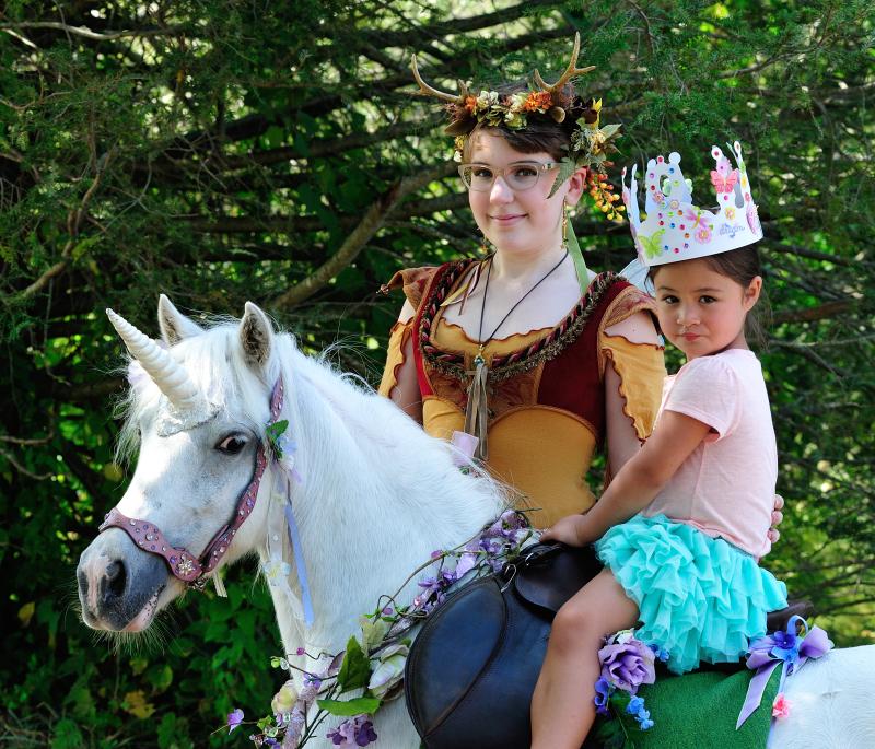birthday girl riding a unicorn at her fairy unicorn party at Schooley Mill Park